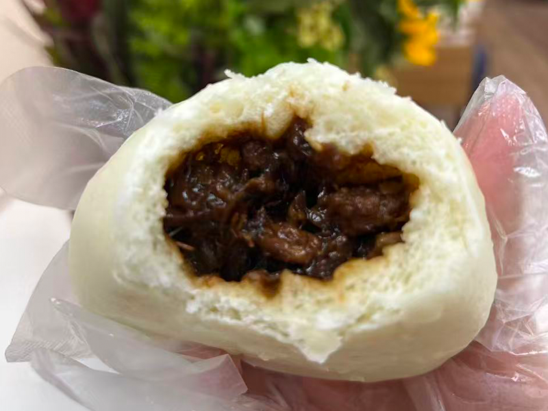 Fluffy bun with tender braised pork & savory sauce at Village Bao 又一村包子，a Chinese Restaurant in Sugar Land